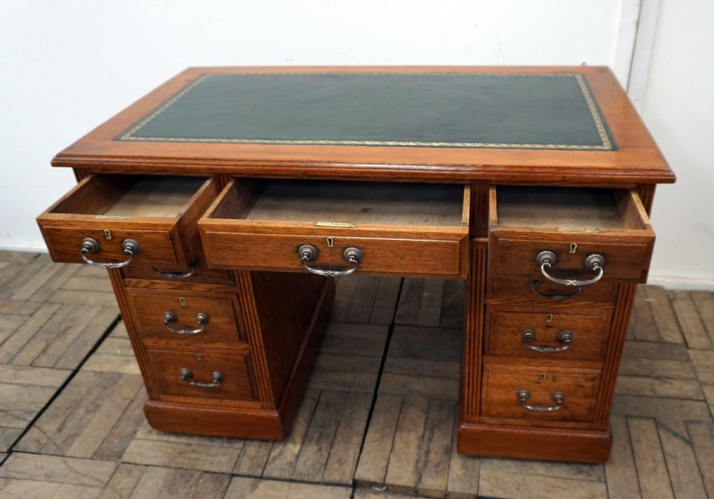 A small clean oak pedastal desk with 9 drawers View IV