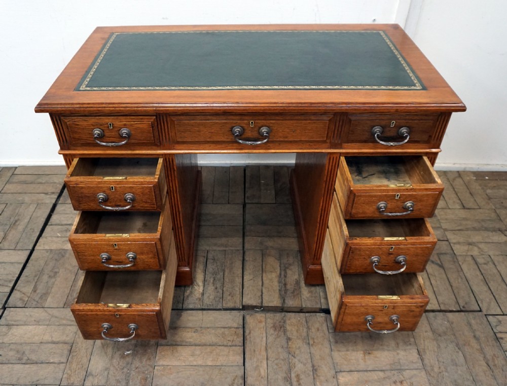 A small clean oak pedastal desk with 9 drawers View V