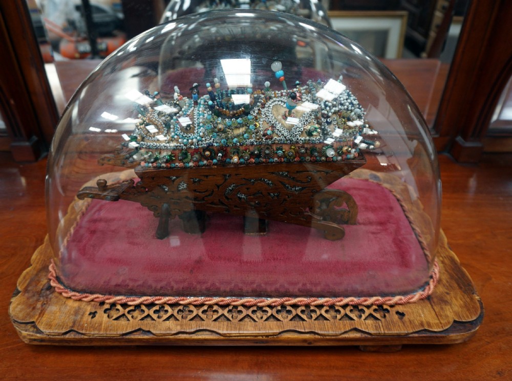 A rare and unusual beedwork wheelbarrow under dome 
