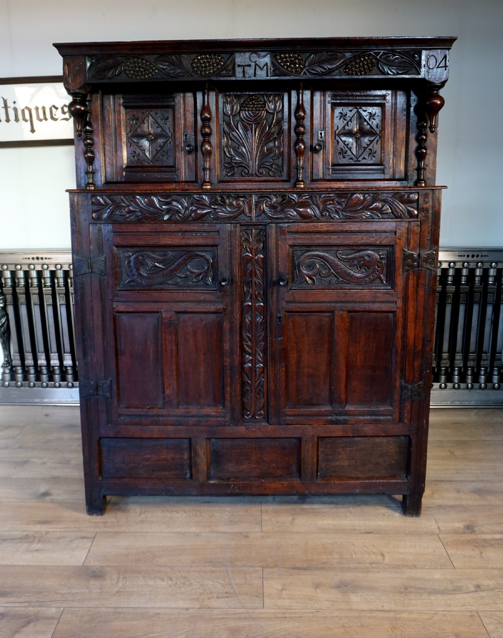 A charming original narrow oak carved court cupboard 