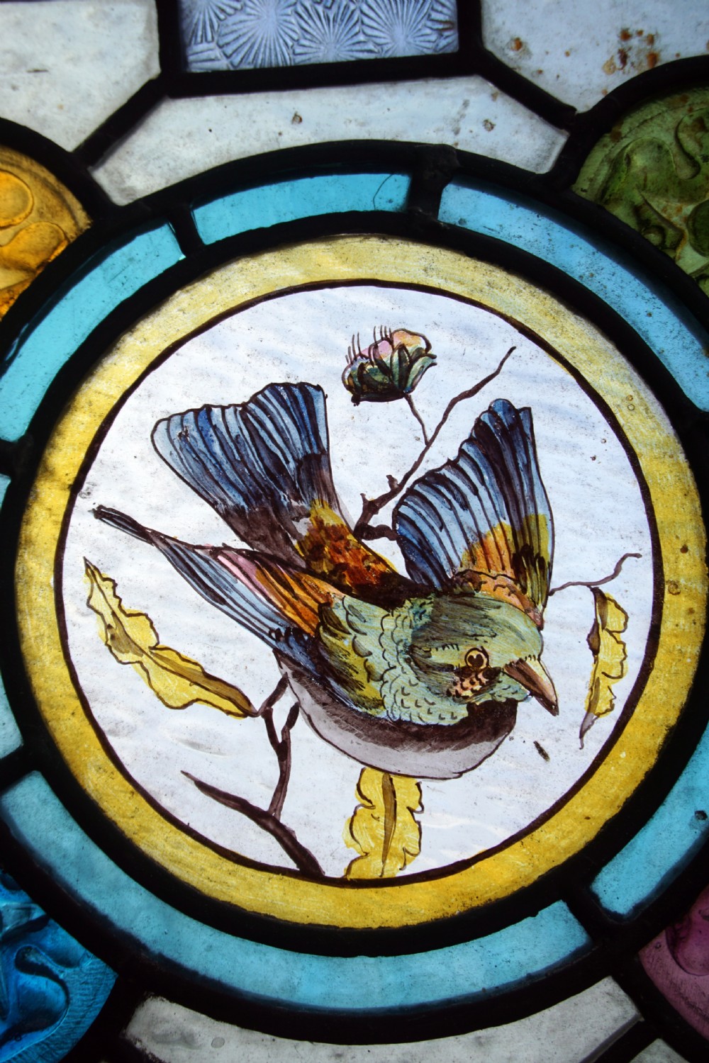 A great stained glass painted window with painted bird centre View III