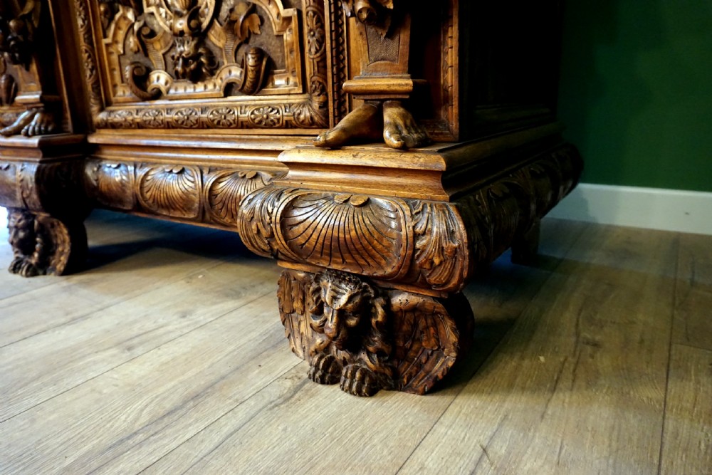 A two-tier carved wooden buffet featuring detailed relief panels of mythological scenes, carved putti, and supporting caryatid figures. View XI