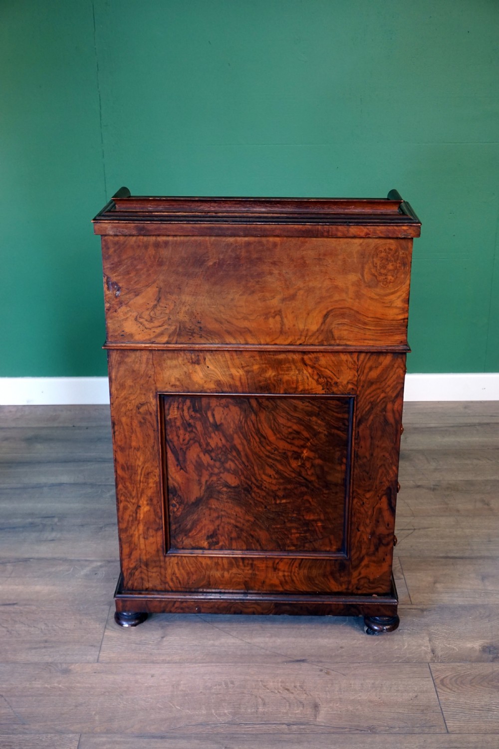 A Victorian burr walnut piano top davenport desk featuring scroll carved supports, side drawers, and a curved writing top section. View VII