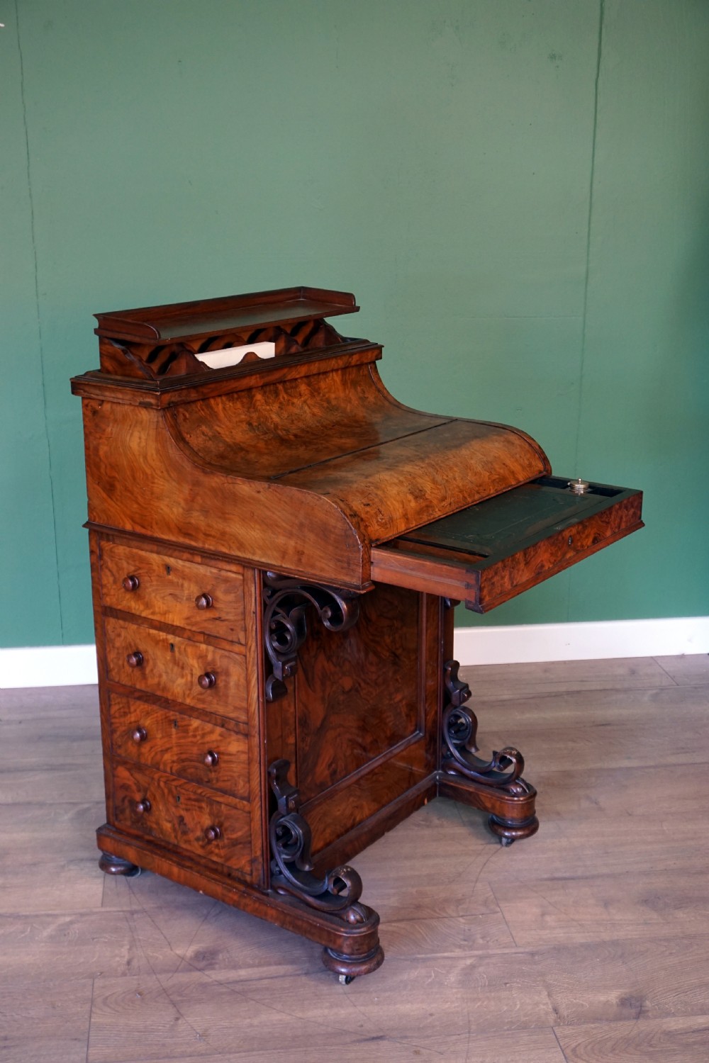 A Victorian burr walnut piano top davenport desk featuring scroll carved supports, side drawers, and a curved writing top section. View VIII