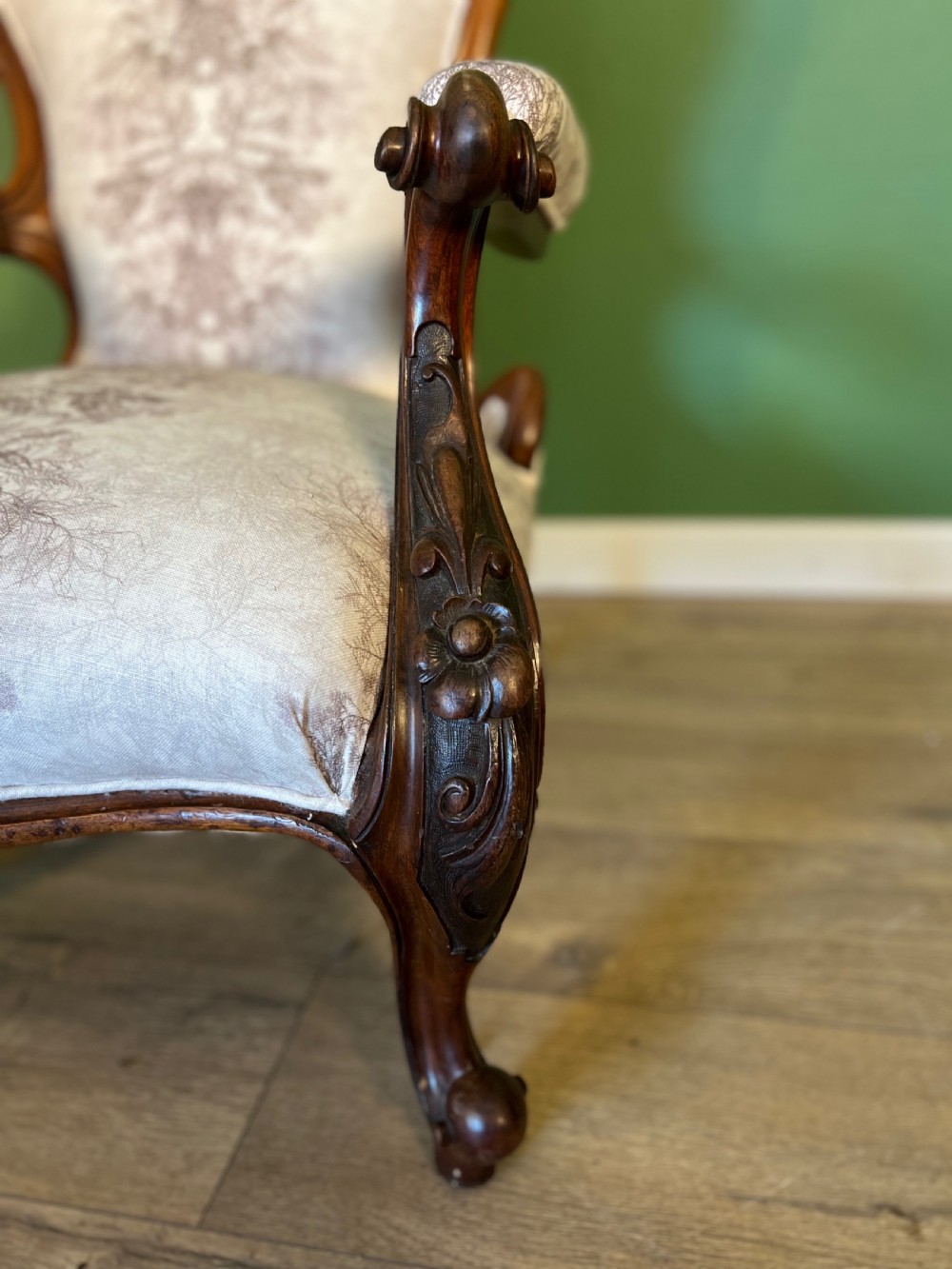 A Victorian mahogany open armchair featuring carved cabriole legs, padded armrests, and patterned fabric upholstery. View IV