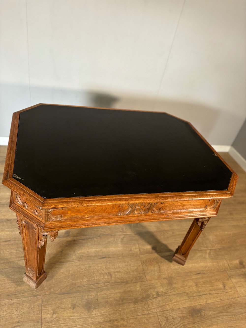 A Victorian Gothic Revival oak writing table featuring a dark leather inset top, carved quatrefoil frieze details, and detailed corner legs on castors. View IX