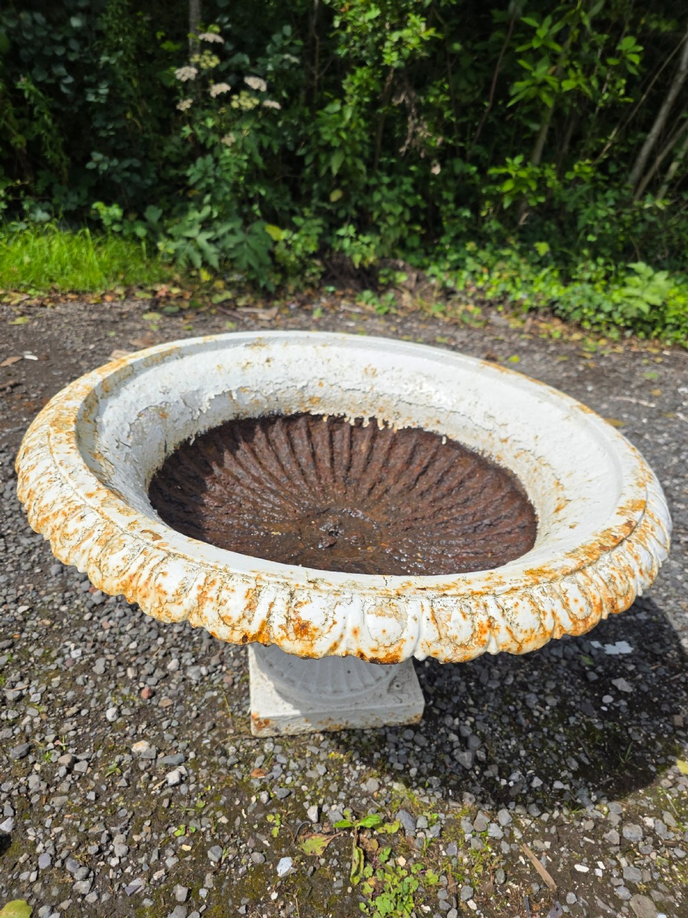 A pair of Victorian cast iron tazza garden urns with fluted basins and weathered white paint. View VII