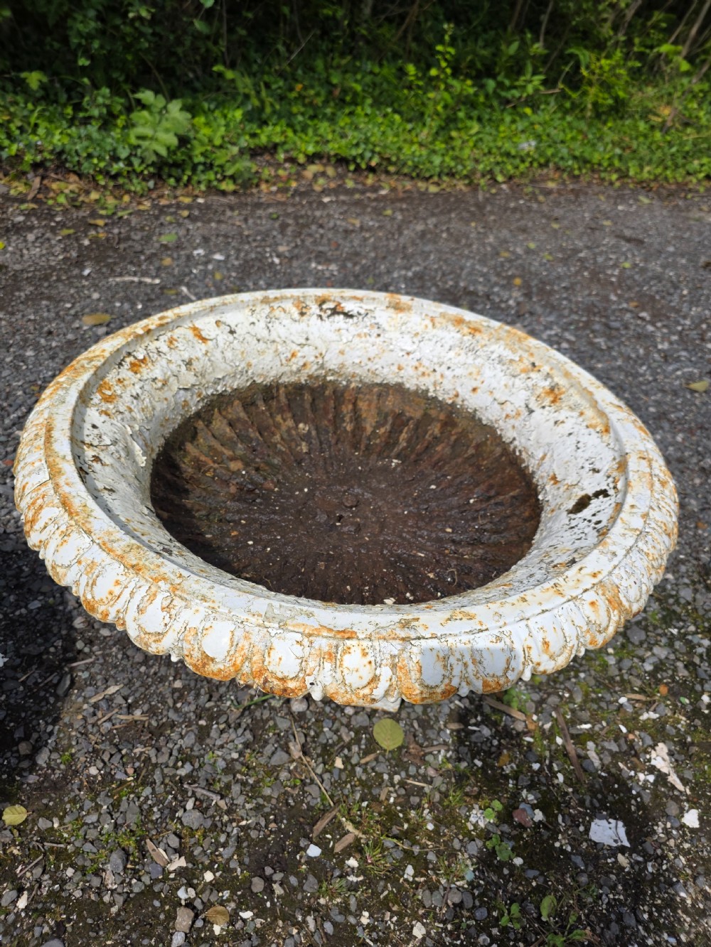 A pair of Victorian cast iron tazza garden urns with fluted basins and weathered white paint. View X