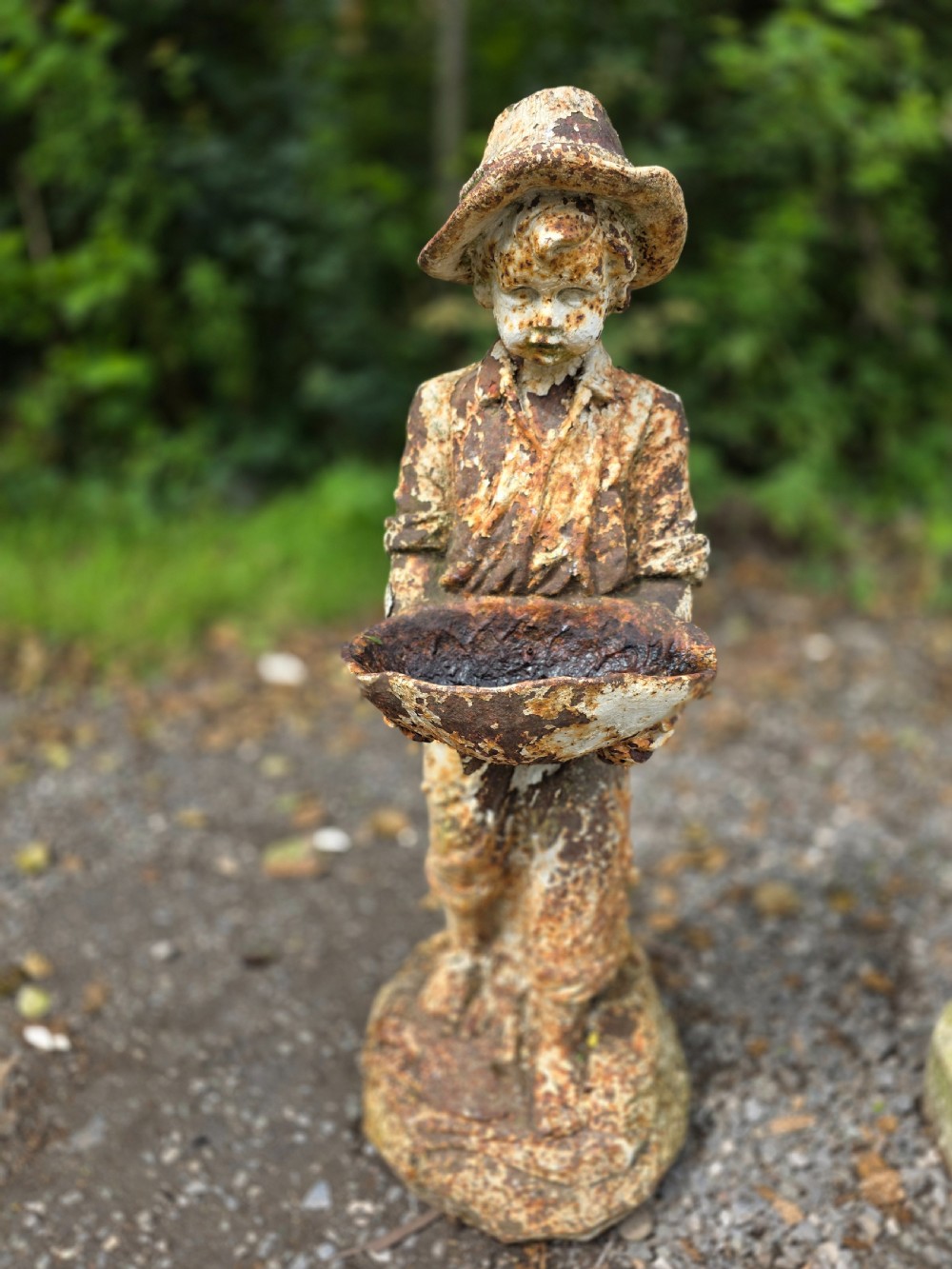 A pair of early 20th-century cast iron garden statues depicting a boy and girl in traditional attire holding small shallow basins. View V