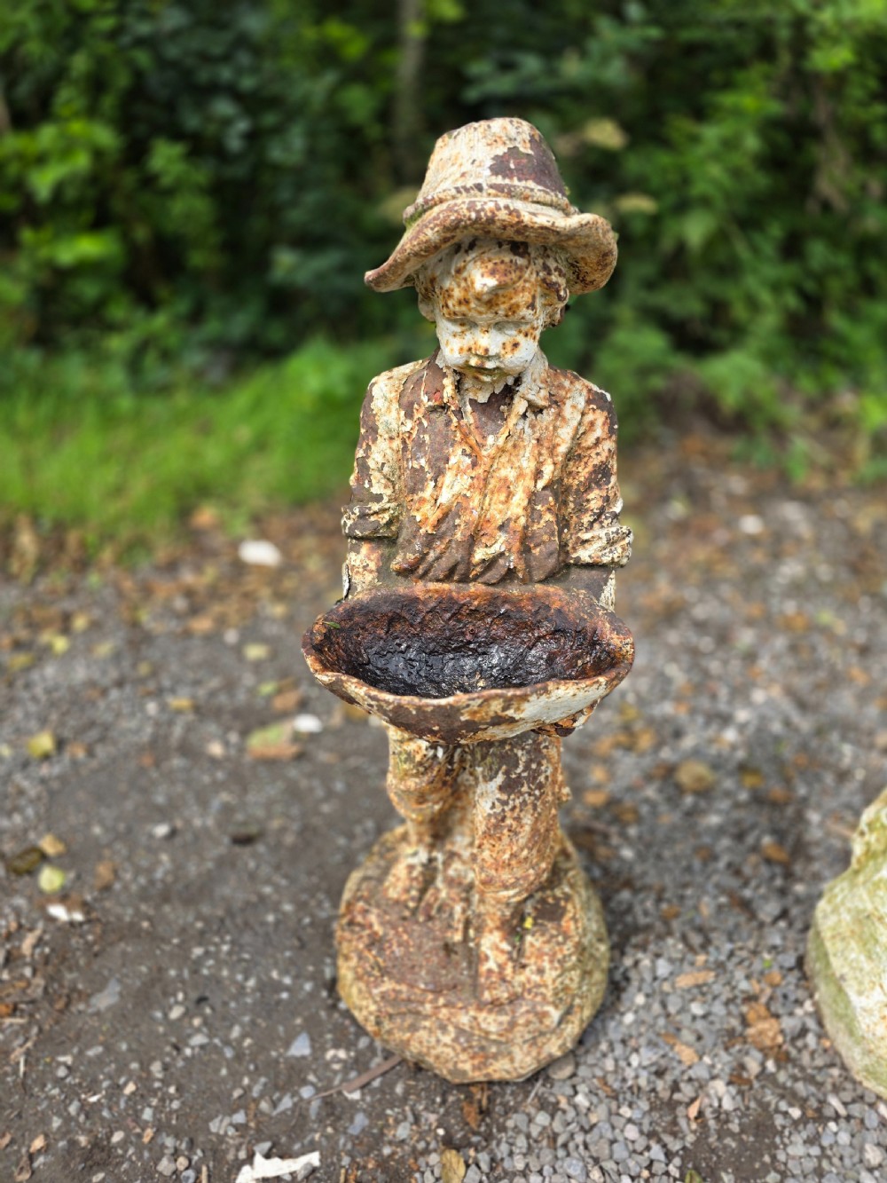 A pair of early 20th-century cast iron garden statues depicting a boy and girl in traditional attire holding small shallow basins. View VI