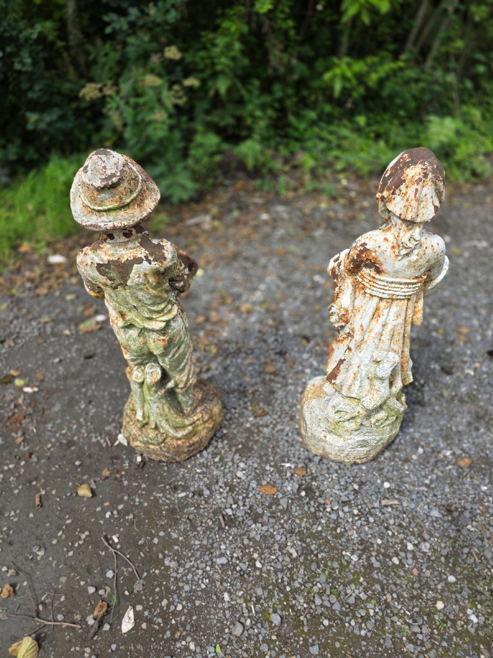 A pair of early 20th-century cast iron garden statues depicting a boy and girl in traditional attire holding small shallow basins. View X