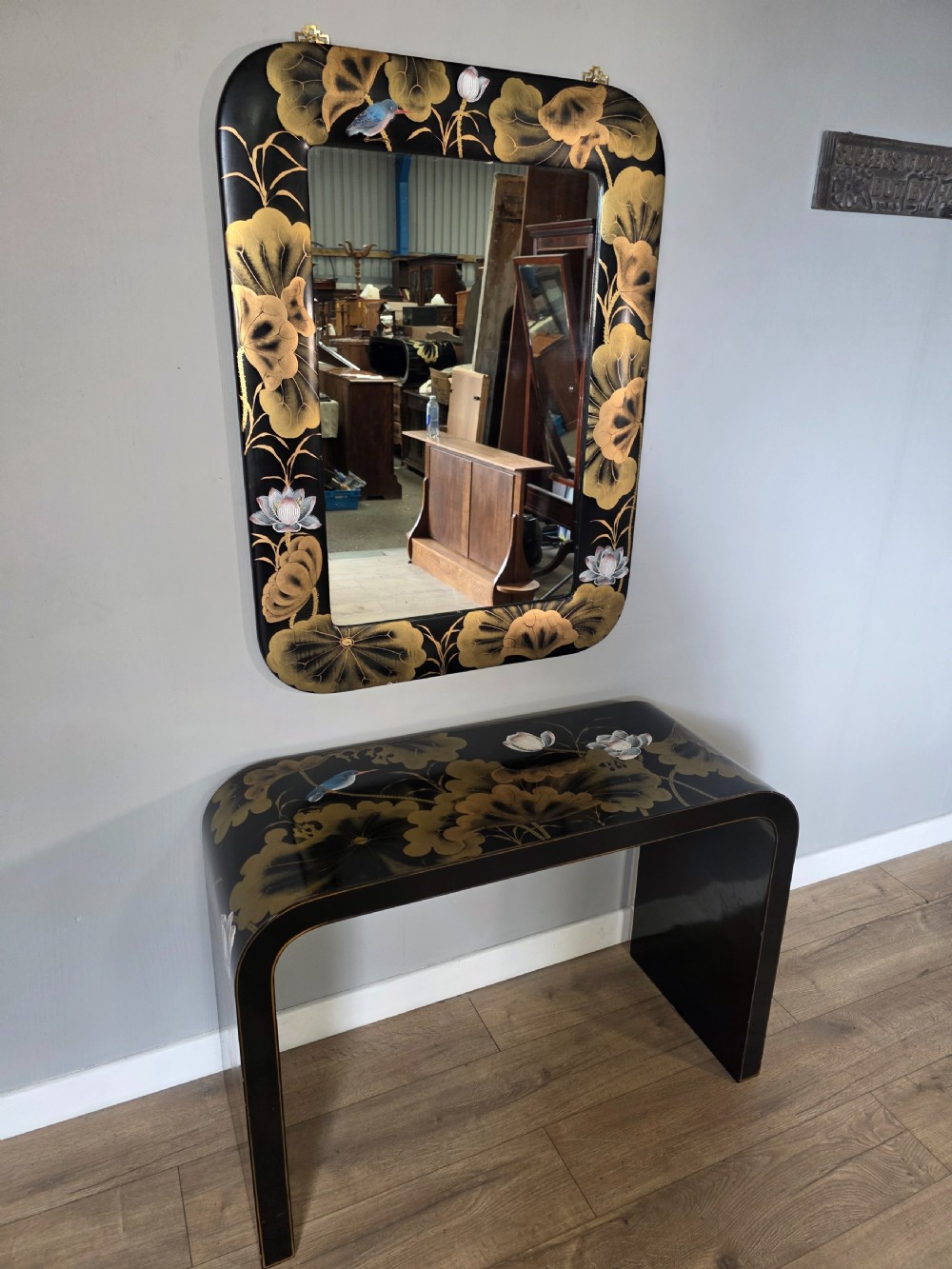 A mid-century black lacquered console table with rounded waterfall edges paired with a matching rectangular wall mirror decorated with hand-painted gold lotus leaves. View VIII