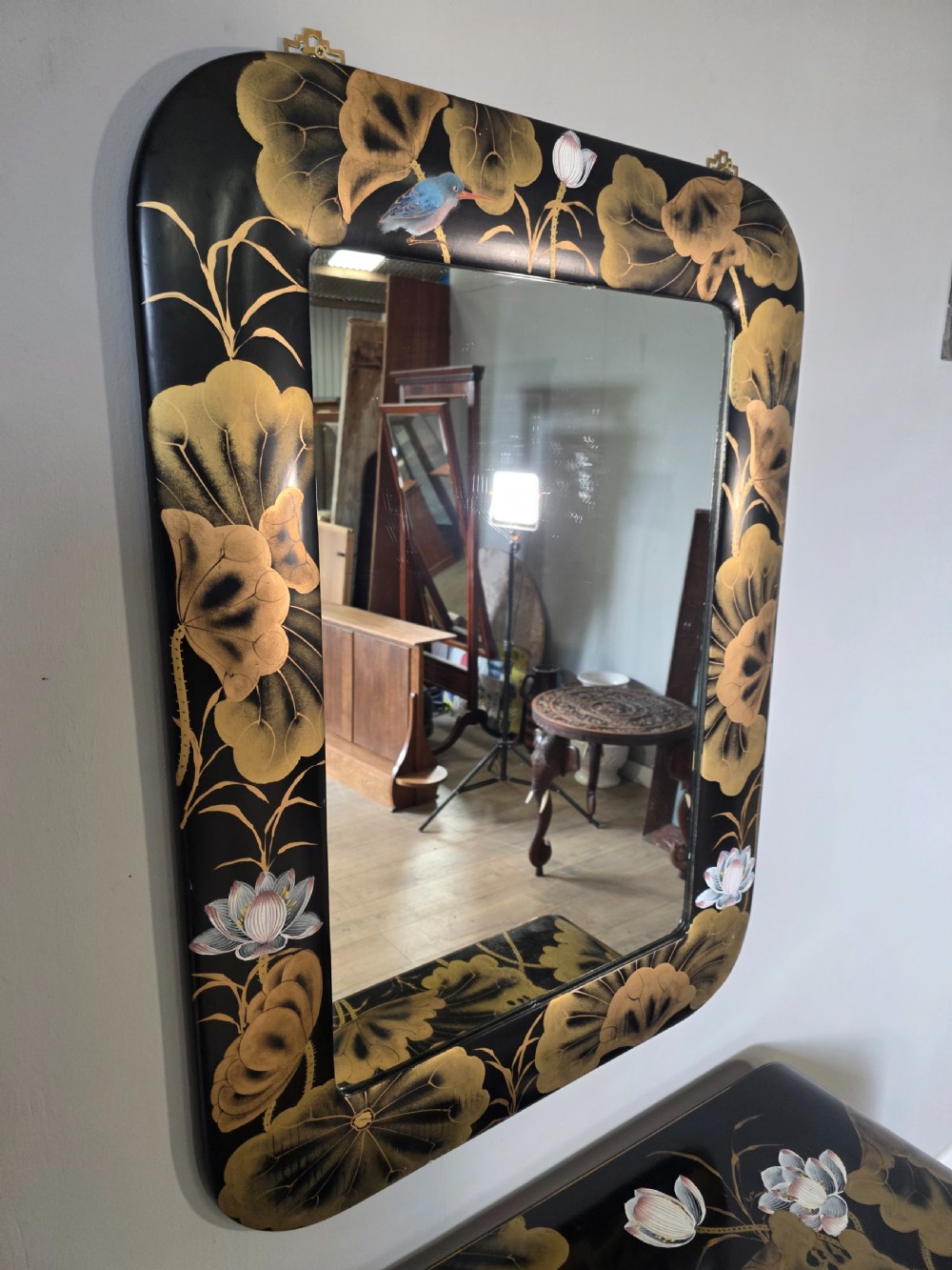 A mid-century black lacquered console table with rounded waterfall edges paired with a matching rectangular wall mirror decorated with hand-painted gold lotus leaves. View XI