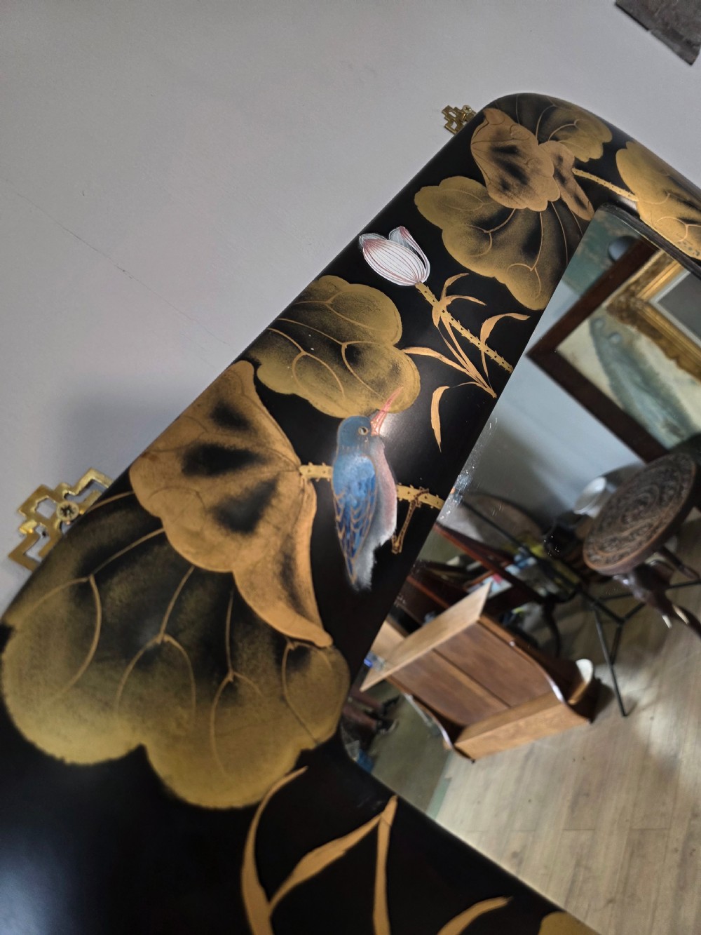 A mid-century black lacquered console table with rounded waterfall edges paired with a matching rectangular wall mirror decorated with hand-painted gold lotus leaves. View XII