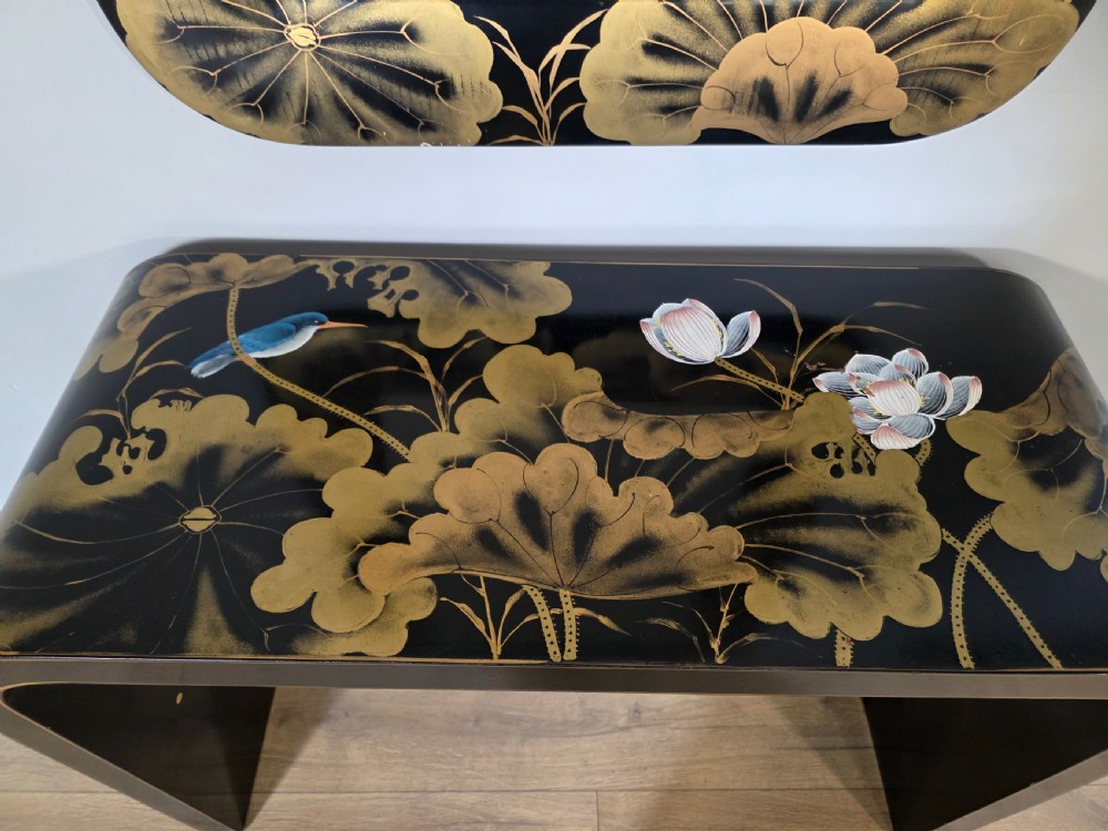 A mid-century black lacquered console table with rounded waterfall edges paired with a matching rectangular wall mirror decorated with hand-painted gold lotus leaves. View XIII