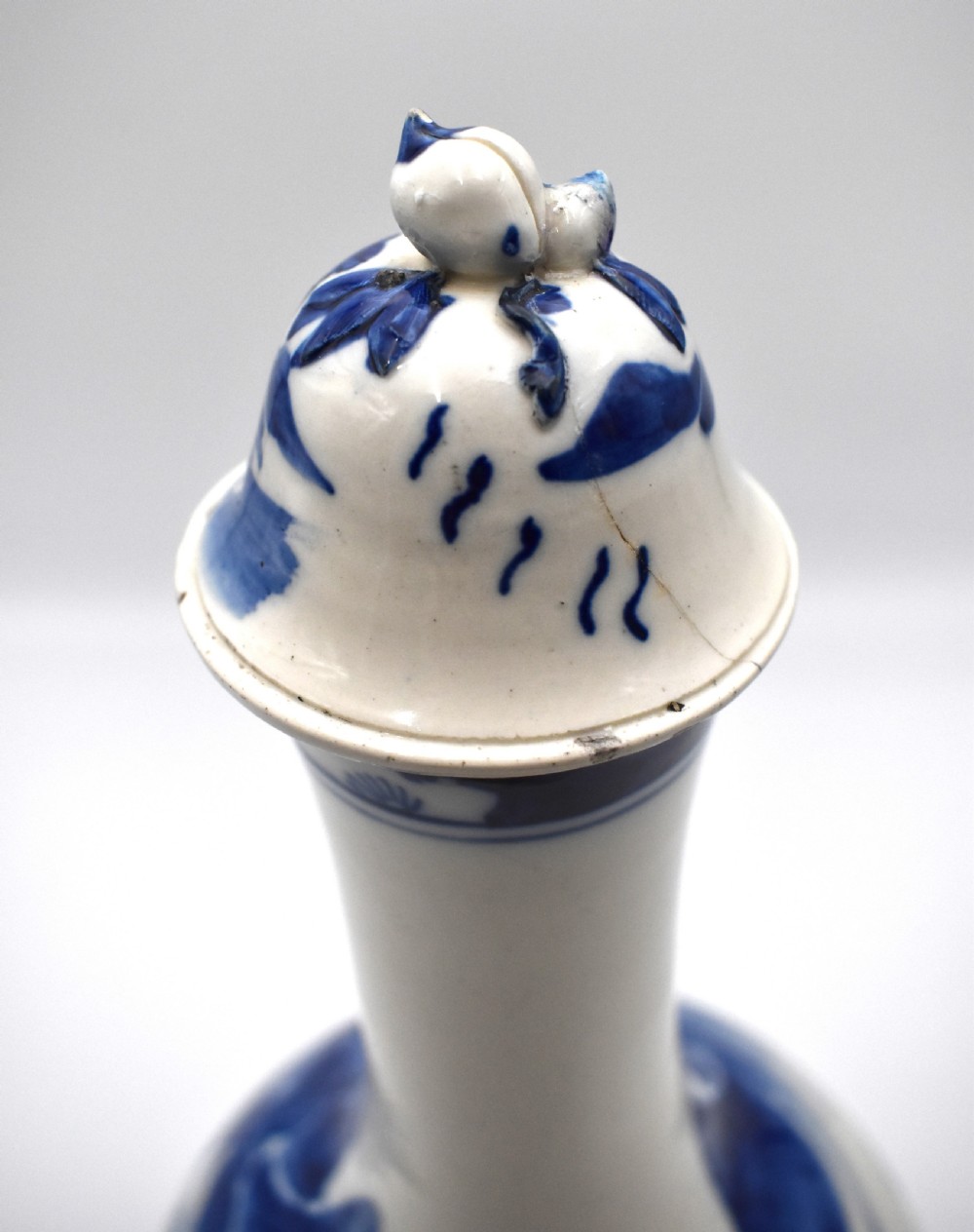 A 19th-century Chinese porcelain bottle vase with a matching lid, featuring hand-painted cobalt blue mountain landscape scenes on a white glazed body. View V