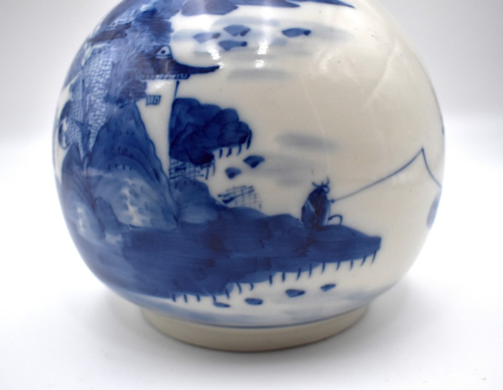 A 19th-century Chinese porcelain bottle vase with a matching lid, featuring hand-painted cobalt blue mountain landscape scenes on a white glazed body. View VIII