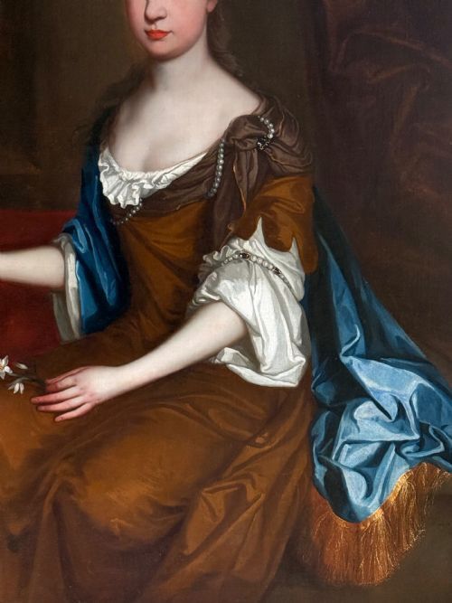 fig 2. A seventeenth-century Baroque oil portrait of a lady in a brown dress and blue drapery, set within a carved giltwood frame.