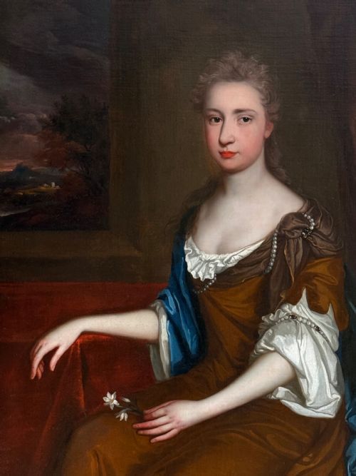 fig 7. A seventeenth-century Baroque oil portrait of a lady in a brown dress and blue drapery, set within a carved giltwood frame.
