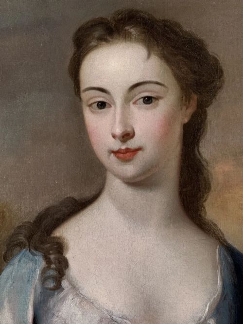 fig 5. An early eighteenth-century oil portrait painting depicting a woman in a blue dress set within an oval feigned surround and a carved giltwood frame.
