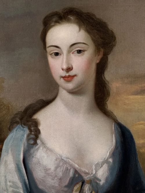 fig 7. An early eighteenth-century oil portrait painting depicting a woman in a blue dress set within an oval feigned surround and a carved giltwood frame.