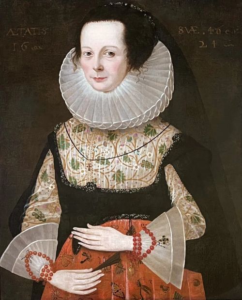 fig 1. A 17th-century oil painting depicting a noblewoman wearing a large white cartwheel ruff collar, embroidered floral bodice, black gown, and red coral bead bracelets.