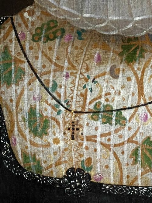 fig 6. A 17th-century oil painting depicting a noblewoman wearing a large white cartwheel ruff collar, embroidered floral bodice, black gown, and red coral bead bracelets.