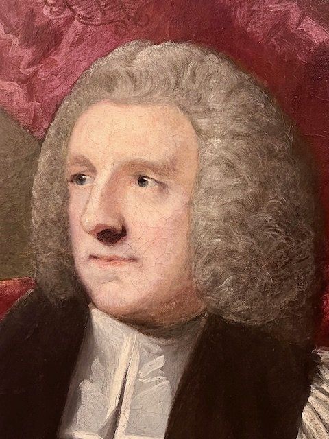 fig 2. An 18th-century oil portrait painting of an archbishop in clerical vestments housed in a carved giltwood frame topped with a mitre cresting.