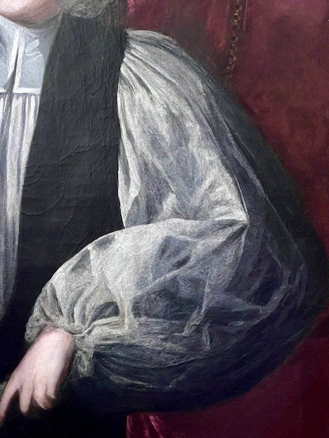 fig 5. An 18th-century oil portrait painting of an archbishop in clerical vestments housed in a carved giltwood frame topped with a mitre cresting.