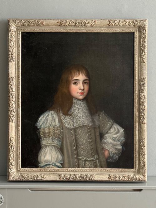 fig 1. A seventeenth-century oil portrait depicting a young gentleman wearing an intricate lace collar and embroidered clothing in a carved silvered frame.