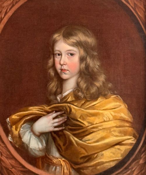 fig 5. A 17th-century oil portrait of a young boy with long curled hair draped in golden-yellow silk, set within a painted trompe loeil oval border.
