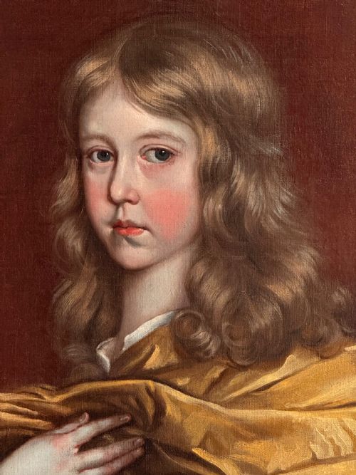 fig 2. A 17th-century oil portrait of a young boy with long curled hair draped in golden-yellow silk, set within a painted trompe loeil oval border.