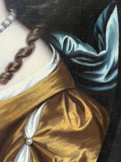 fig 3. A 17th-century oil portrait of a woman wearing a gold and blue gown with pearl jewellery, painted within a feigned oval canvas frame.