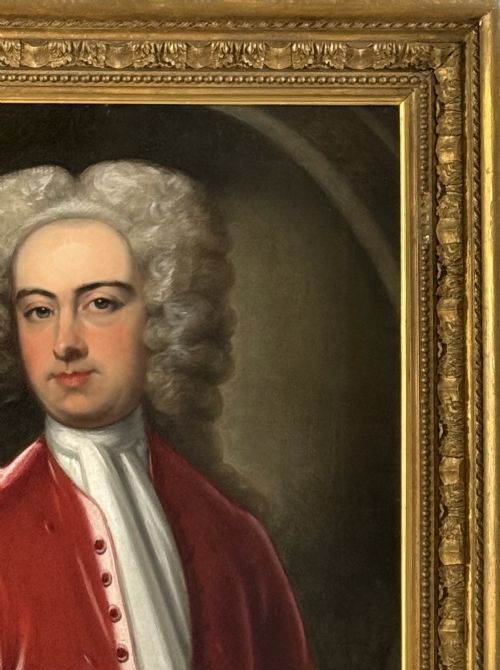 fig 1. An early 18th-century oil portrait painting on canvas depicting a gentleman in a red coat and powdered wig within a feigned oval composition.