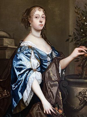 fig 5. A seventeenth-century portrait painting of a lady in a blue silk dress picking oranges, set within an ornate gilded frame.