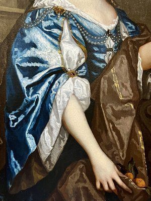 fig 7. A seventeenth-century portrait painting of a lady in a blue silk dress picking oranges, set within an ornate gilded frame.