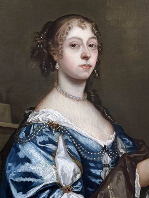 fig 9. A seventeenth-century portrait painting of a lady in a blue silk dress picking oranges, set within an ornate gilded frame.
