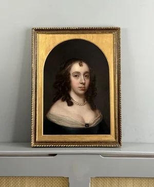 fig 5. A 17th-century oil portrait of a woman with dark ringlets, wearing a pearl necklace and a dark dress against a plain background.