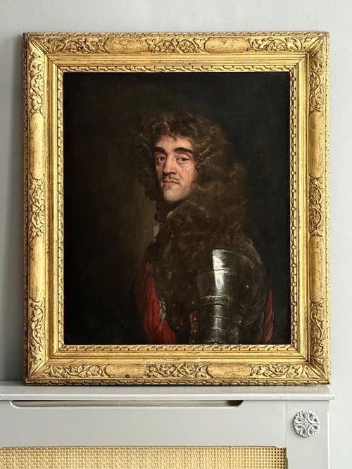 fig 5. A half-length oil painting depicting a 17th-century gentleman with long dark curled hair wearing polished steel plate armour over a red sash against a dark backdrop.