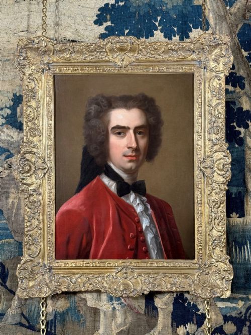 fig 1. An eighteenth-century oil portrait of a gentleman in a scarlet coat with a white cravat, set inside a carved giltwood frame.