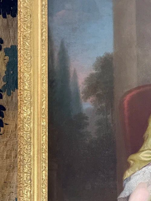 fig 2. An 18th-century oil portrait depicting a seated lady in a chartreuse silk dress with lace trim holding a book.