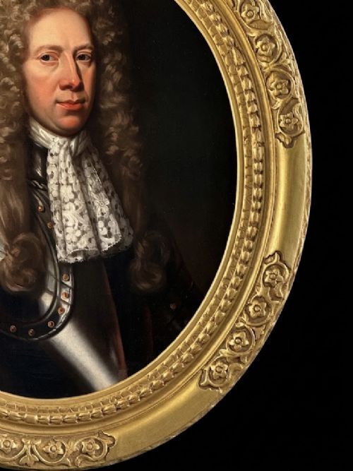 fig 2. A late 17th-century oil painting depicting a gentleman wearing plate armour, a powdered wig, and a lace cravat, set within an oval carved gilded frame.