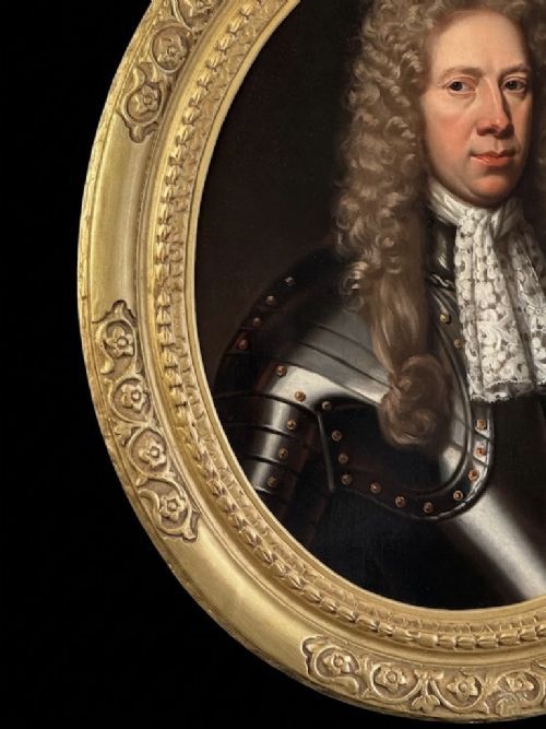 fig 5. A late 17th-century oil painting depicting a gentleman wearing plate armour, a powdered wig, and a lace cravat, set within an oval carved gilded frame.