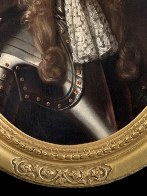 fig 6. A late 17th-century oil painting depicting a gentleman wearing plate armour, a powdered wig, and a lace cravat, set within an oval carved gilded frame.