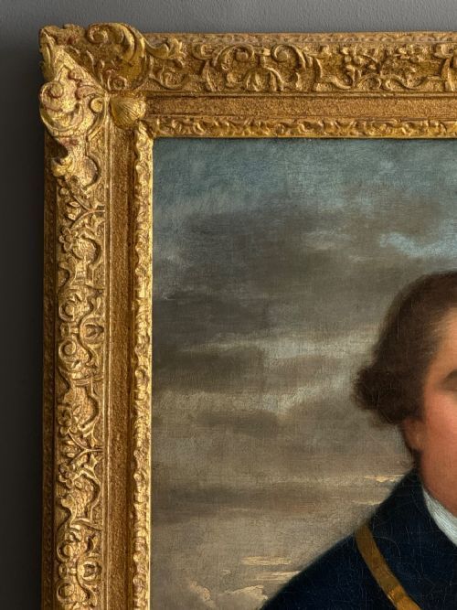 fig 4. An 18th-century oil painting on canvas depicting a merchant navy captain in a blue uniform coat holding a rolled sea chart within an ornate gilt frame.