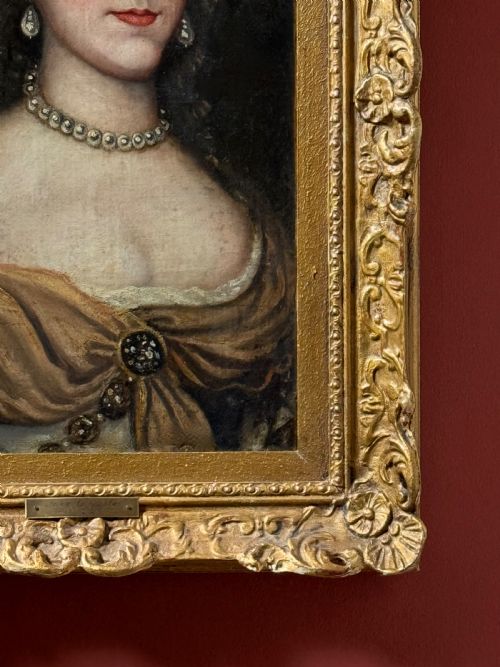 fig 3. A seventeenth-century oil painting on canvas depicting a noblewoman with pearl jewellery, housed within an ornate carved gilt frame.