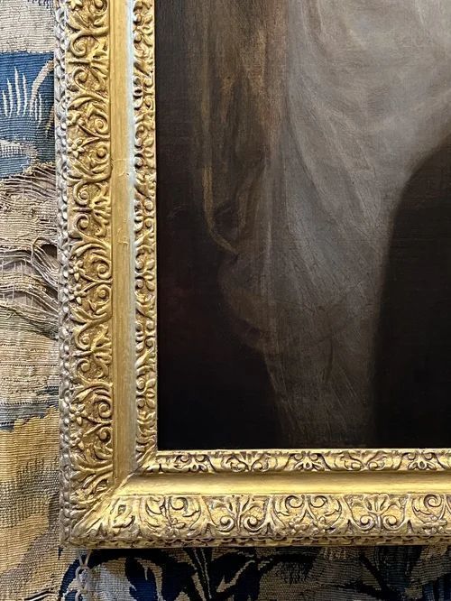 fig 5. An 18th-century oil painting on canvas depicting a young woman in a white gown having her palm read by a figure in a red cloak, displayed within an ornate gilded frame.