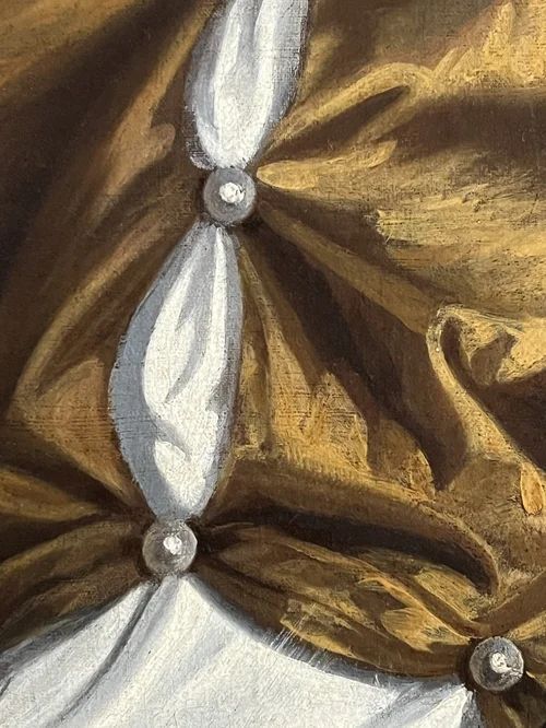 fig 8. An oil portrait on canvas depicting a 17th-century woman with curled hair, wearing a pearl necklace and a golden gown trimmed with blue drapery, set within a painted feigned oval spandrel.