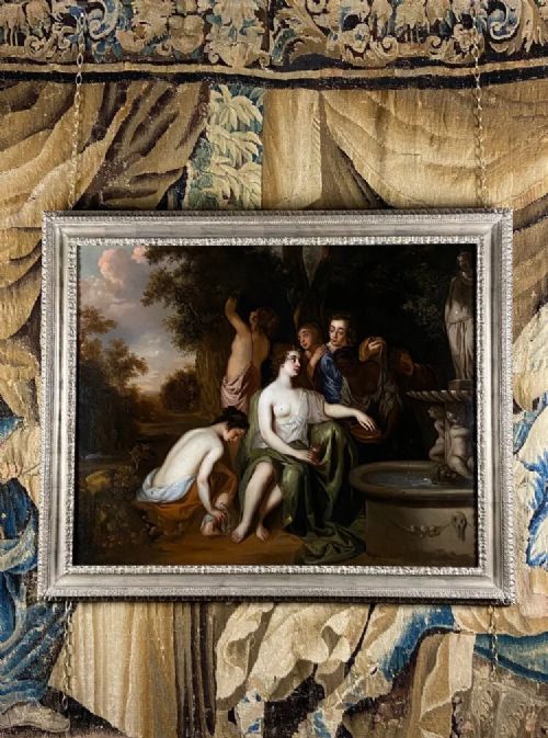 fig 1. A classical oil painting framed in carved silvered wood depicting mythological figures gathered around a stone fountain in a shaded woodland landscape.