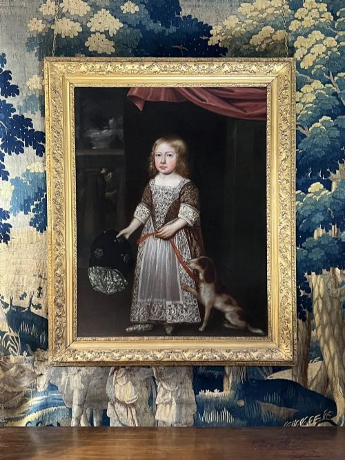 fig 6. A 17th-century oil portrait depicting a young boy standing beside a dog, framed in an ornate giltwood border.